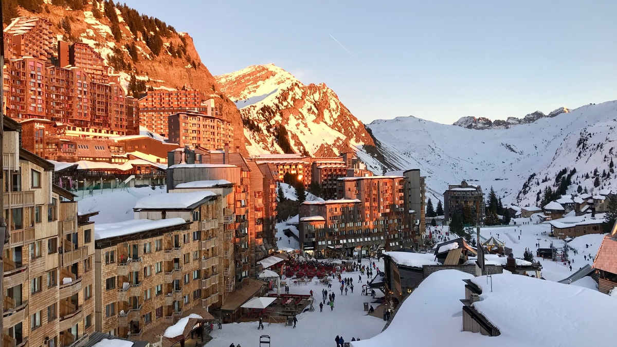 Avoriaz's wooden-clad apartment blocks lit by evening sun above snowy slopes